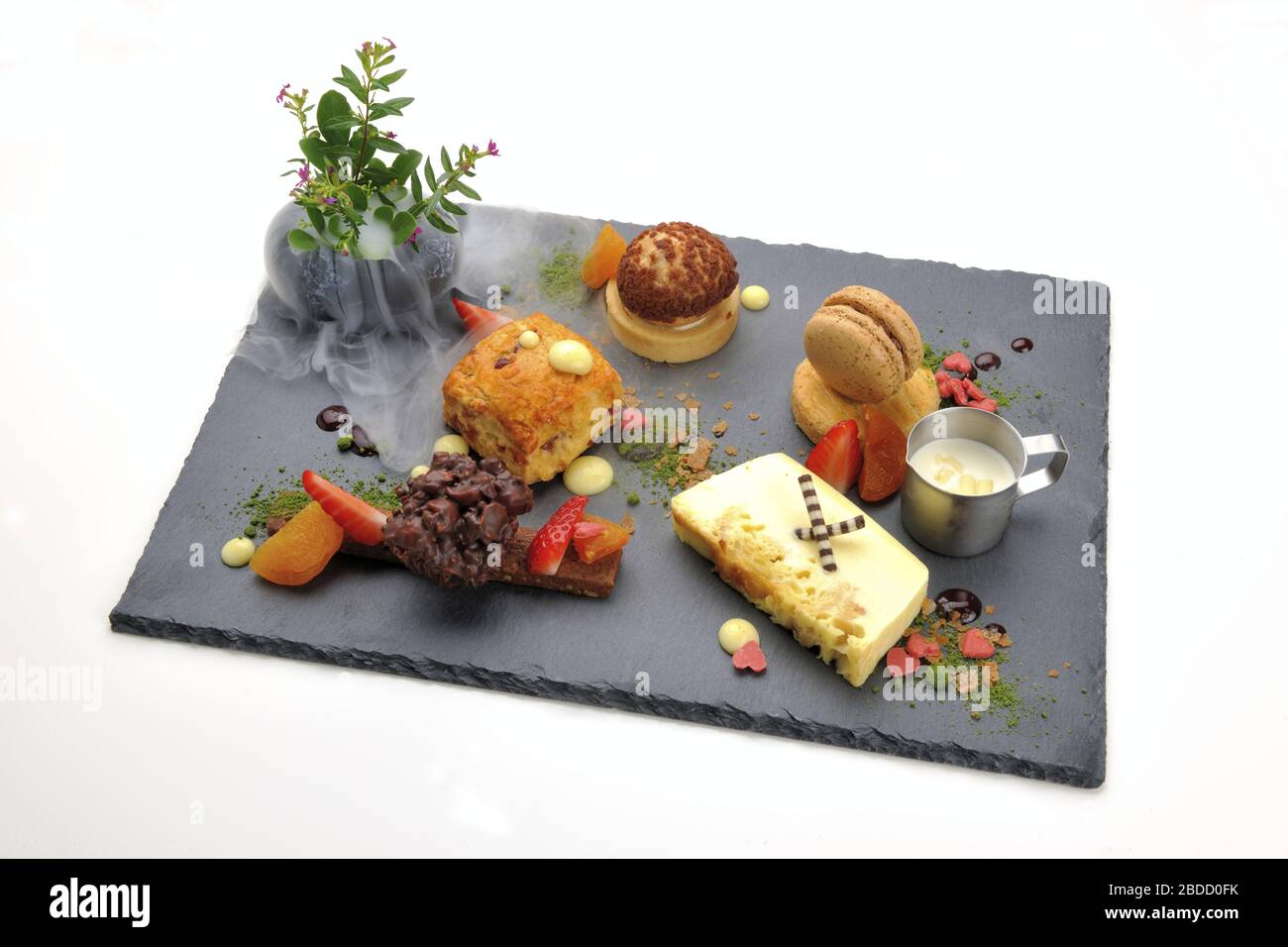 Various desserts served on the black plate Stock Photo