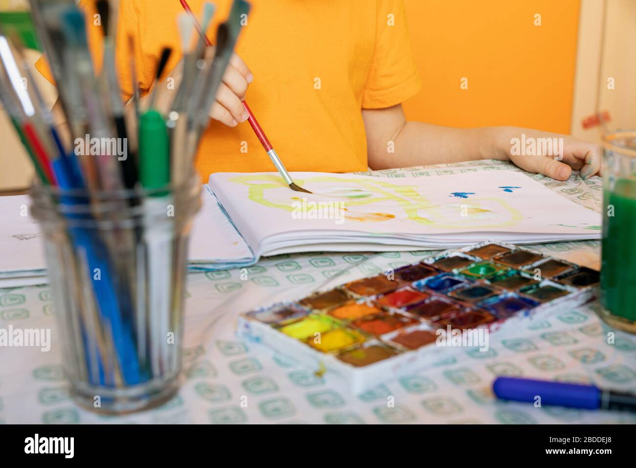 drawing materials on blurred background and the child is painting
