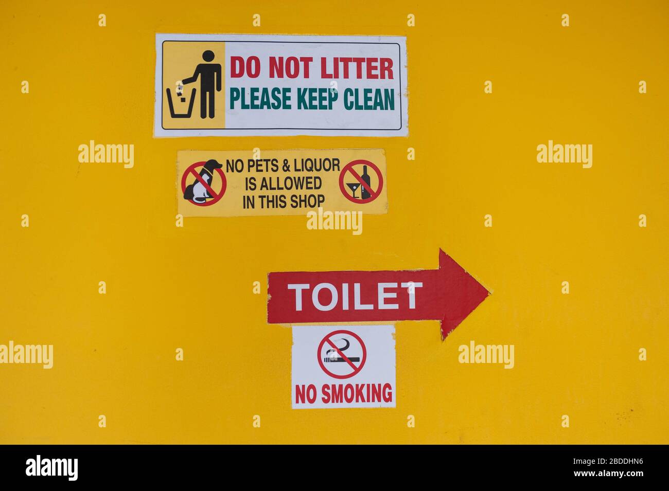 18.07.2019, Singapore, , Singapore - Various prohibition signs and stickers with notices stick to a yellow house wall in the Muslim quarter. 0SL190718 Stock Photo