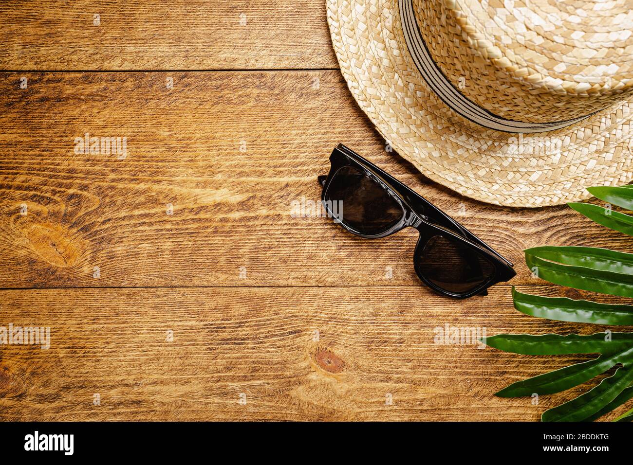 Straw beach hat and sun glasses top view on wooden background, summer flat  lay Stock Photo - Alamy