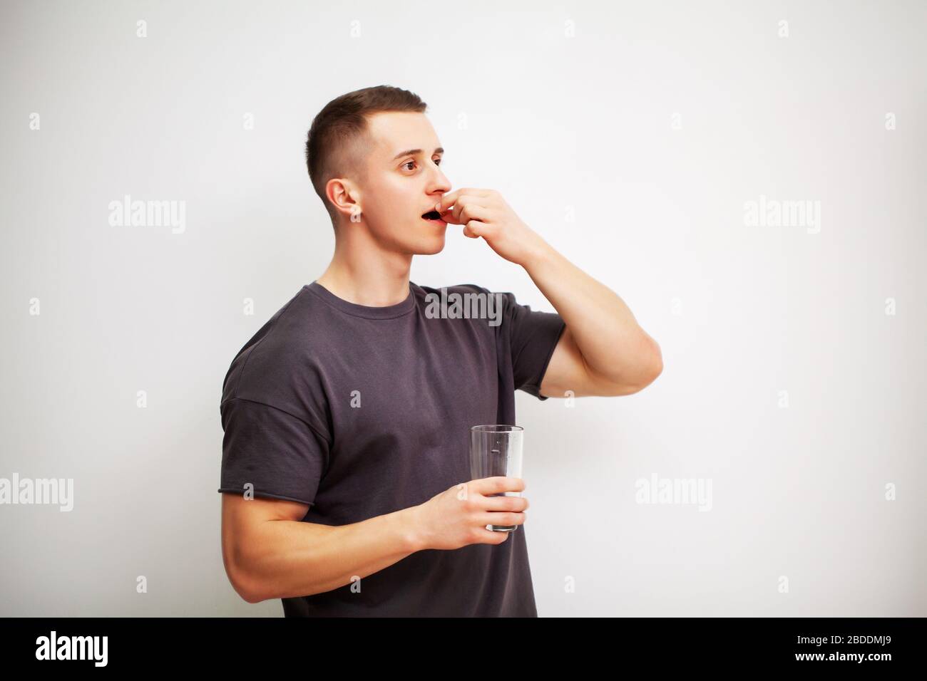 Man takes a pill of amino acids after training Stock Photo Alamy