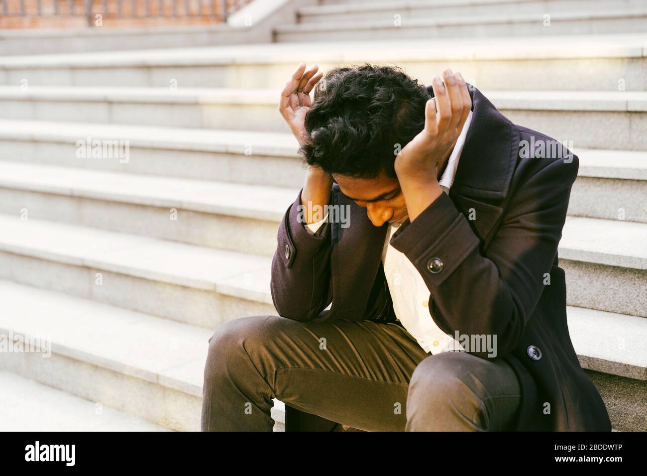 Young handsome Indian man in a white shirt and a business suit is sitting  Stock Photo