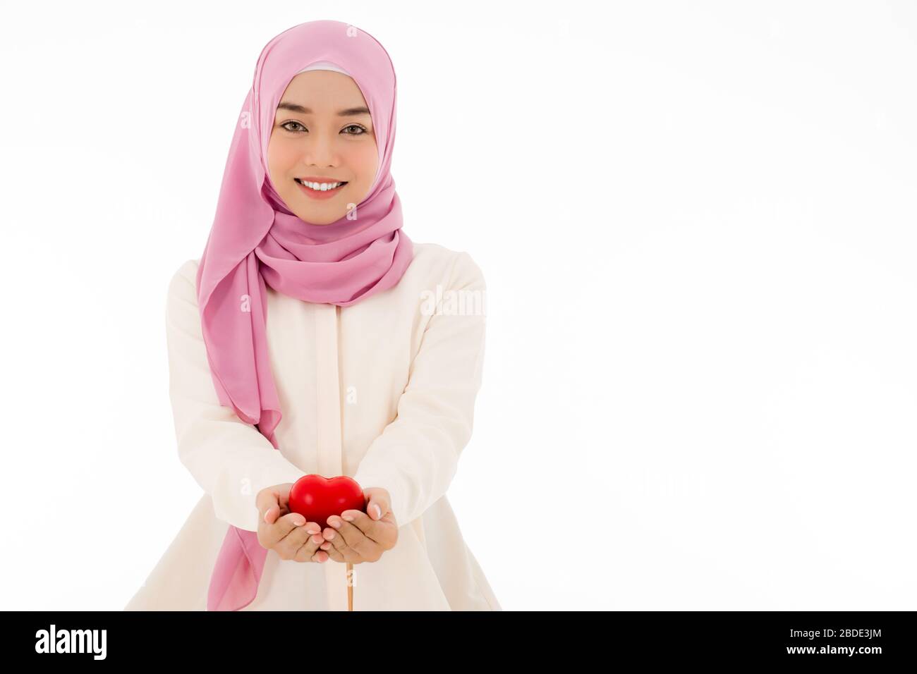 Portrait of Muslim woman in hijab holding red heart with a beautiful ...