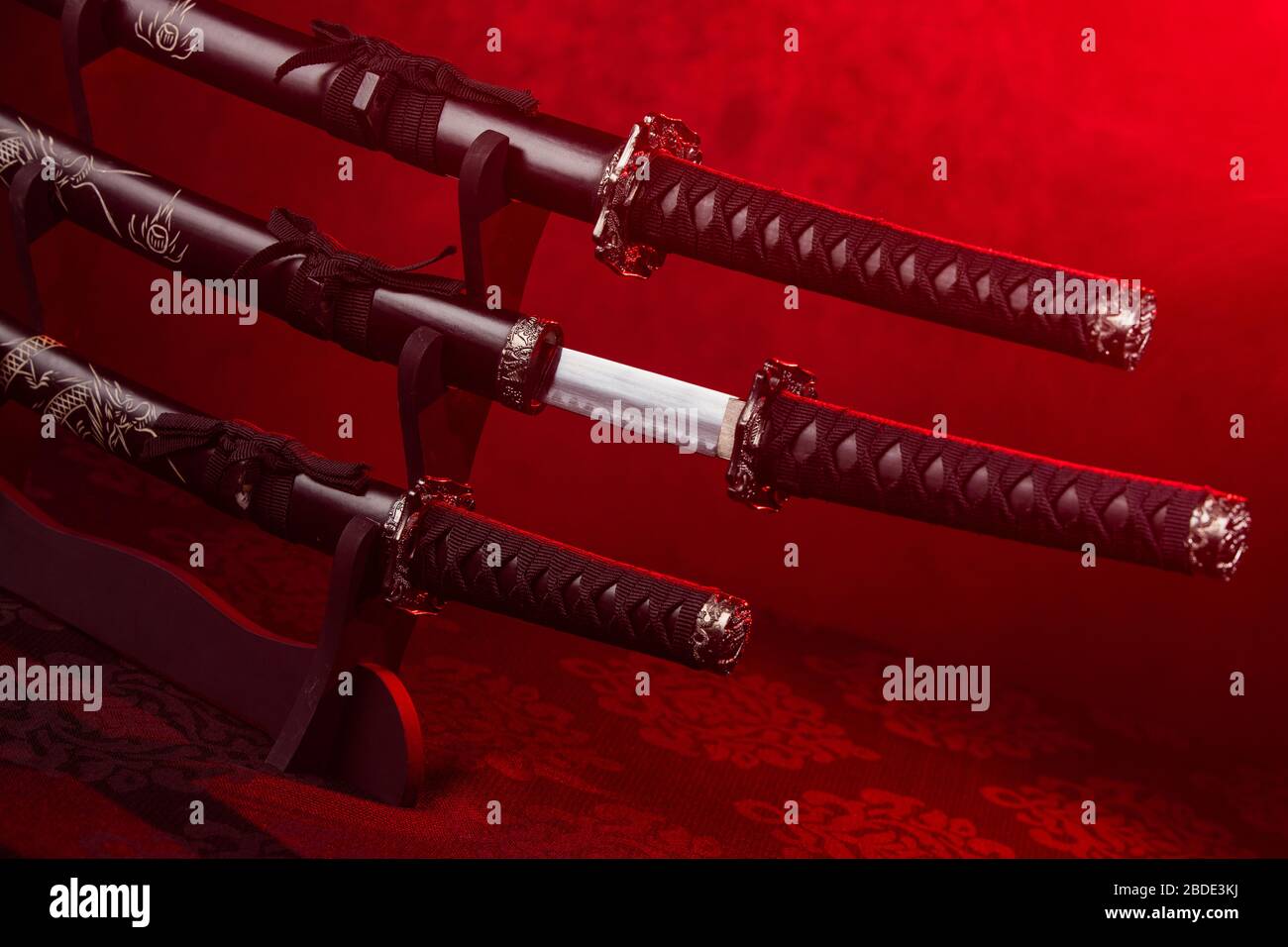 Stand with swords, middle one partially exposed, red light Stock Photo