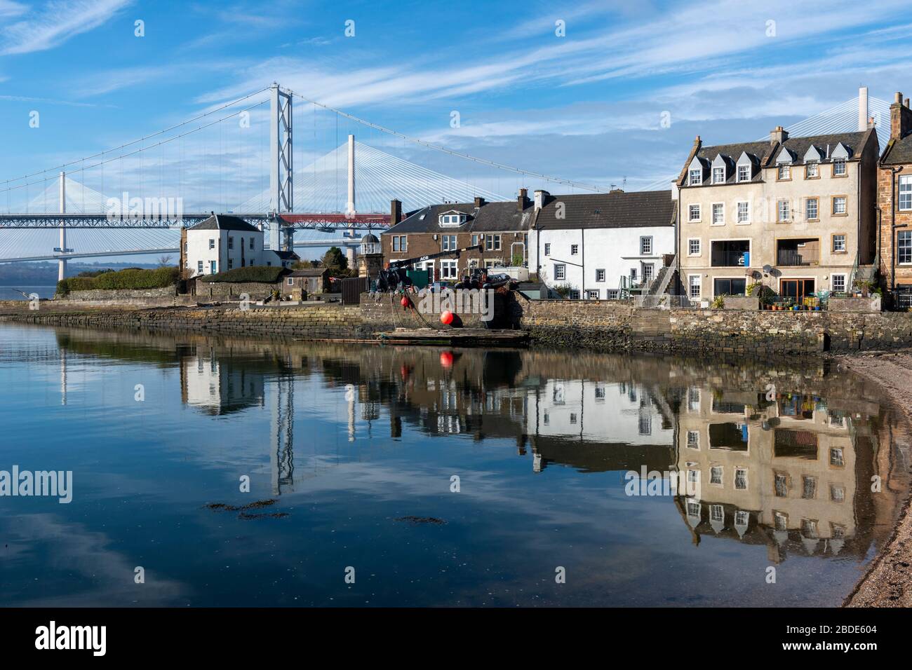 Houses on Main Street on South Bay, with Forth Road Bridge and Queensferry Crossing in background - North Queensferry, Fife, Scotland, UK Stock Photo