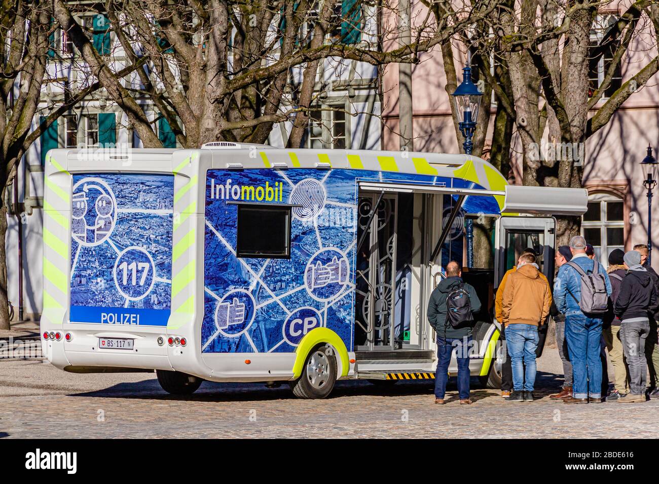 A police community information vehicle with a crowd outside it in the city centre of Basel, Switzerland. February 2020. Stock Photo