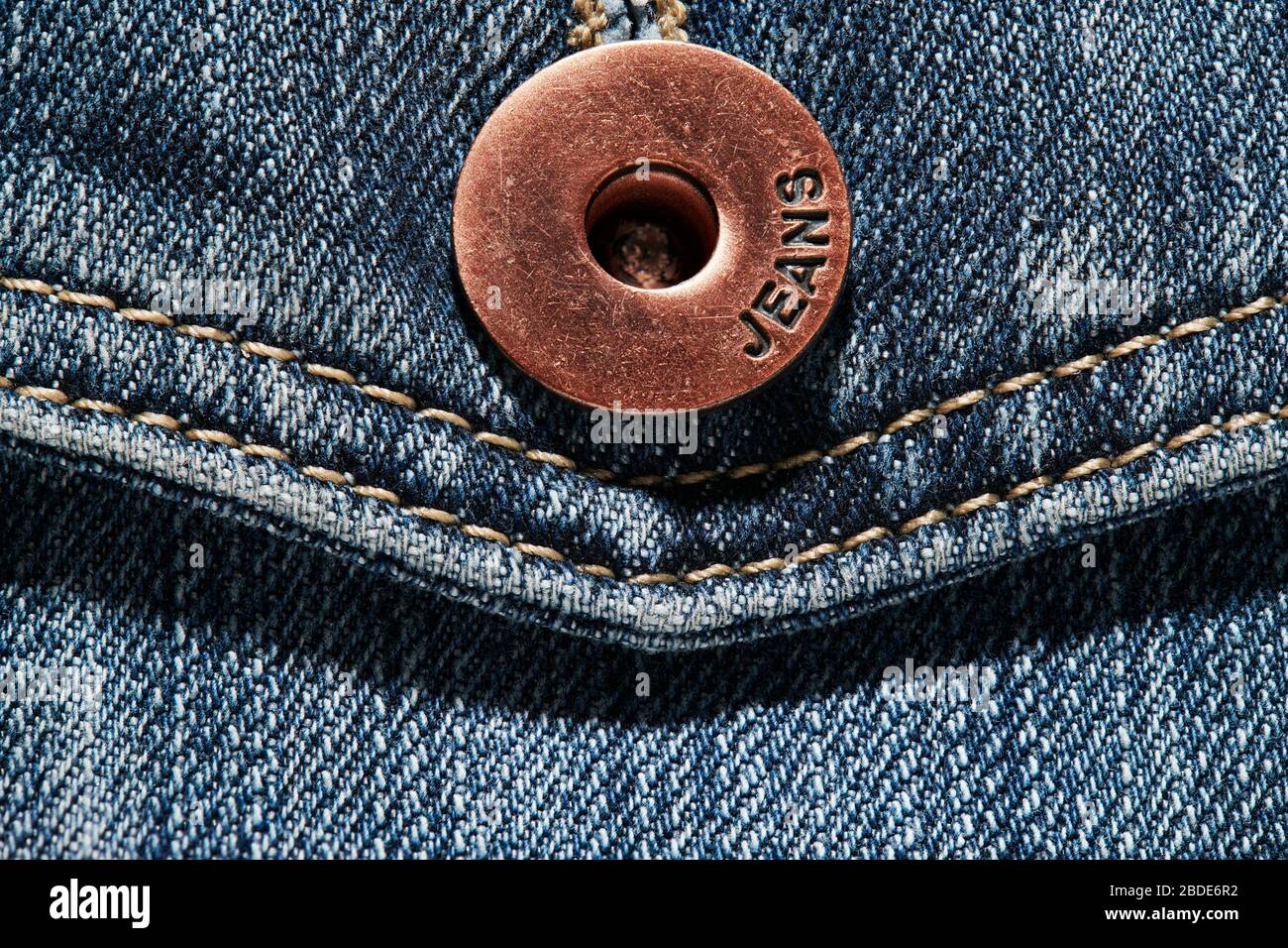 pocket and a brass button with jeans natural clean background macro