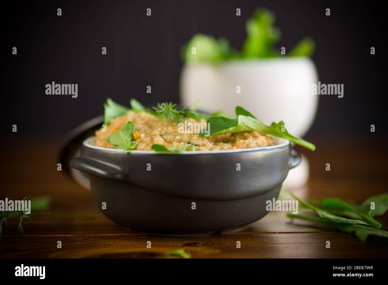 boiled bulgur groats with vegetables and herbs in a ceramic bowl Stock Photo