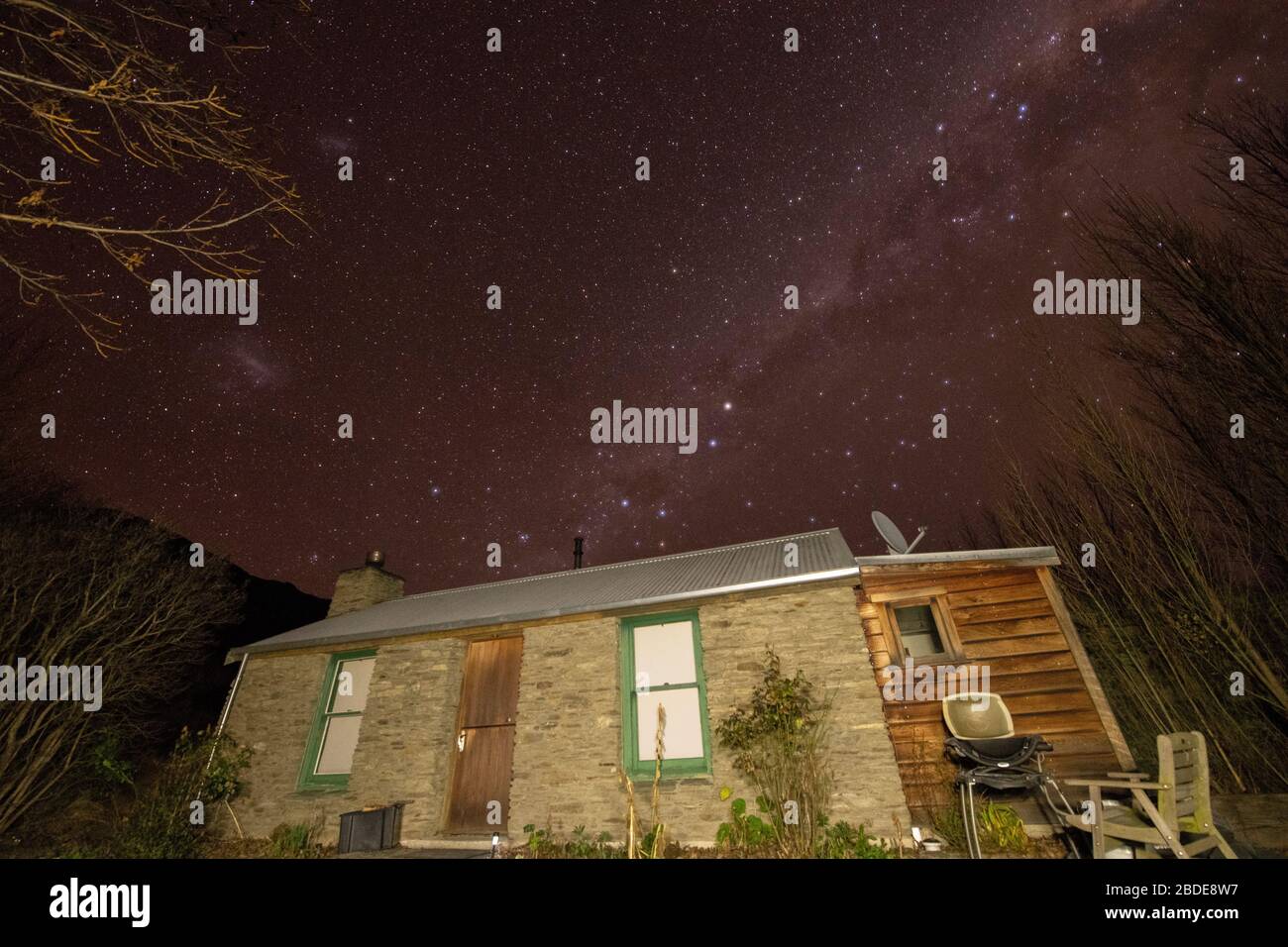 Milky Way above Warbrick Stone Cottage, historic 1864 goldminer's cottage, Cromwell, Otago district, South Island, New Zealand Stock Photo