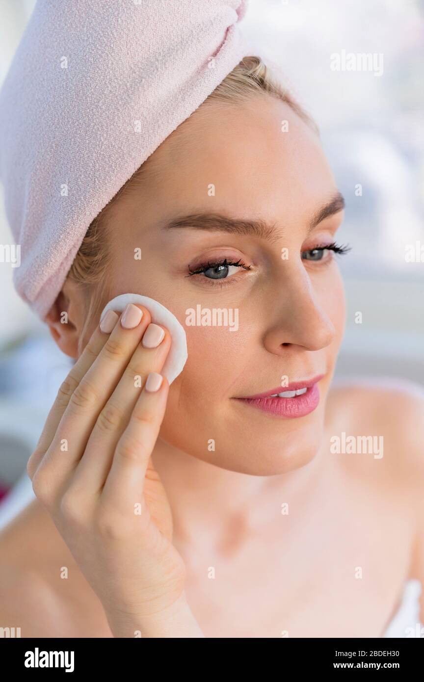 Woman cleaning face with cotton pad Stock Photo