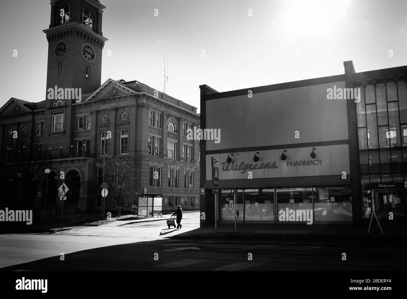 Deliveryman has street to himself as he leaves Walgreen's pharmacy in downtown Montpelier, VT, USA, during state stay-at-home order. Stock Photo