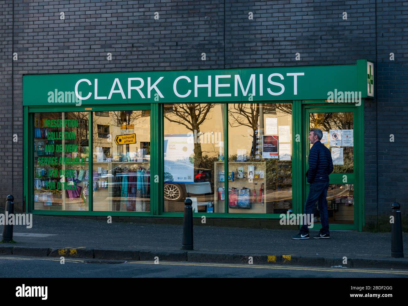 Leith, Edinburgh, Scotland, UK, 8th Apr 2020. Covid-19 lockdown: people continue in lockdown and maintain social distancing. People queue outside a chemist shop Stock Photo