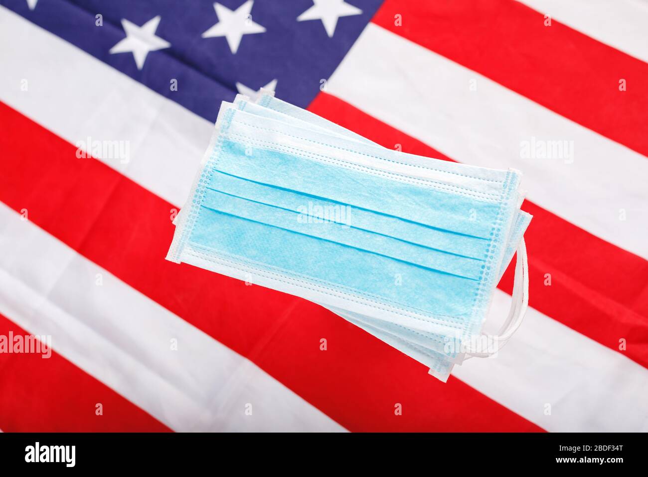 Coronavirus in USA. Protective surgical face mask on American national flag. U.S. flag and hygienic mask as symbol of protection prevention viral Stock Photo