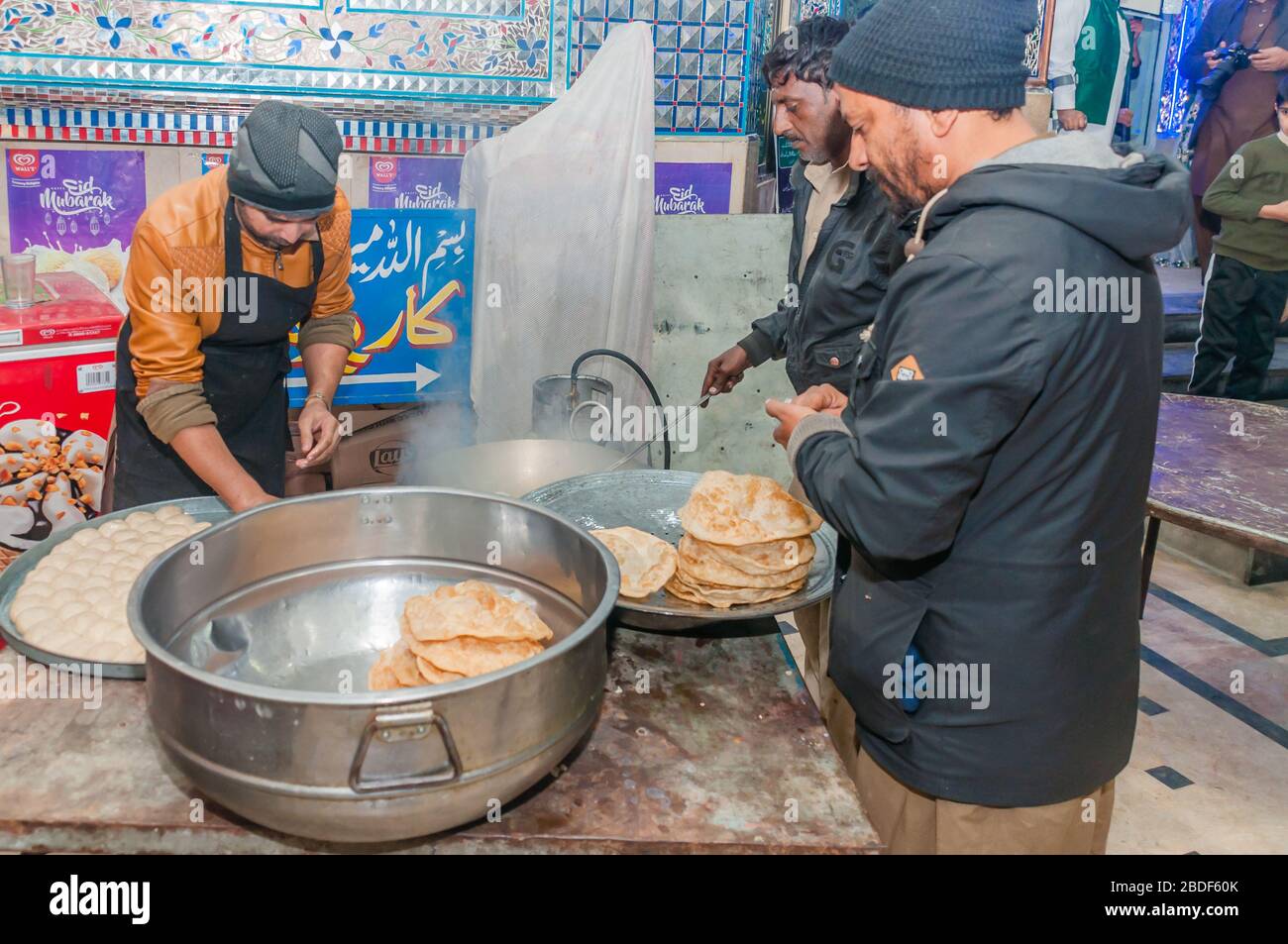 Men prepare Deep fried poori in the kitchen, crispy very popular street food, Jhelum, Punjab