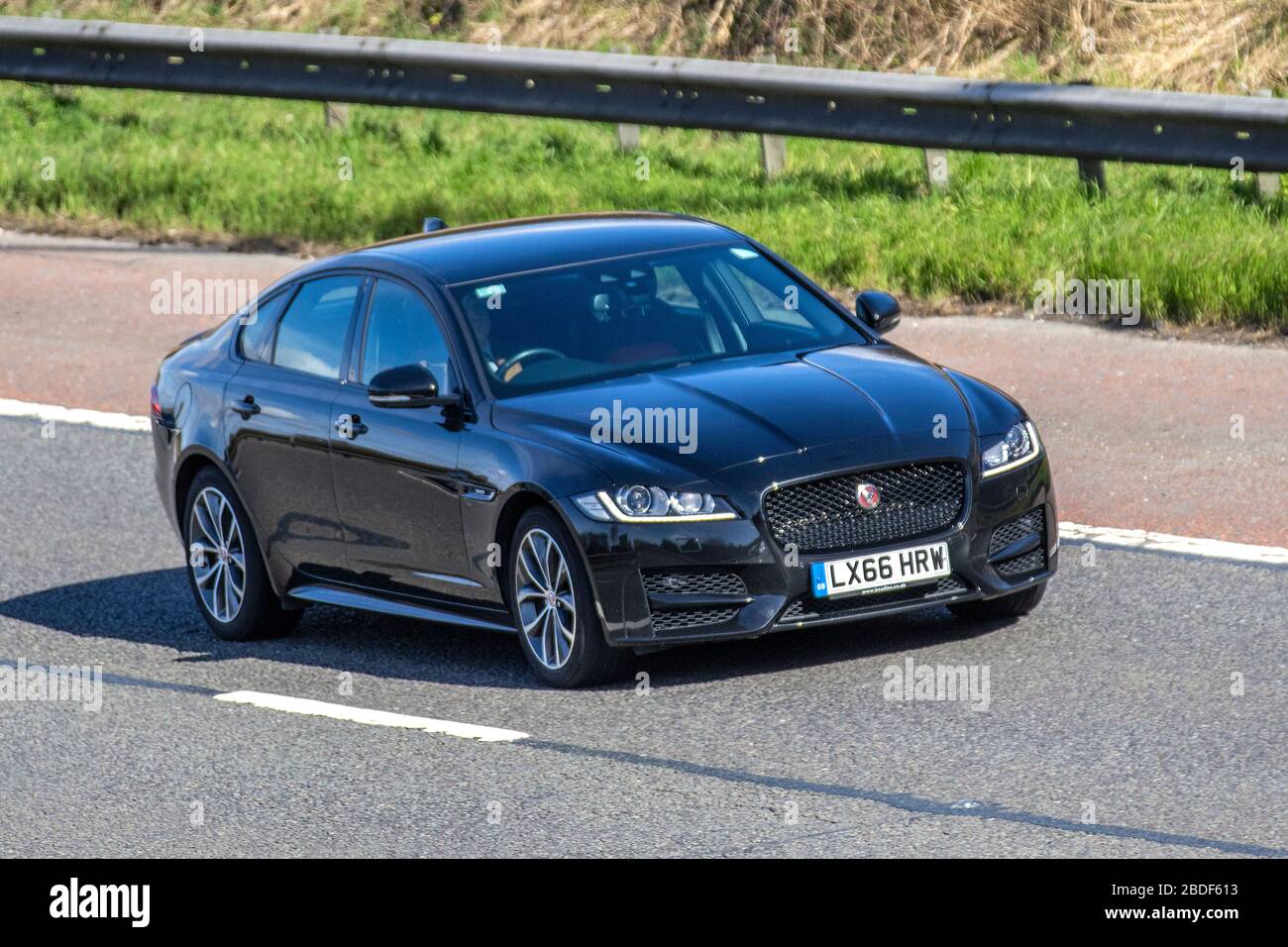 2016 black Jaguar XF R-Sport D Auto; Vehicular traffic moving vehicles, driving vehicle on UK roads, motors, motoring on the M6 motorway highway Stock Photo