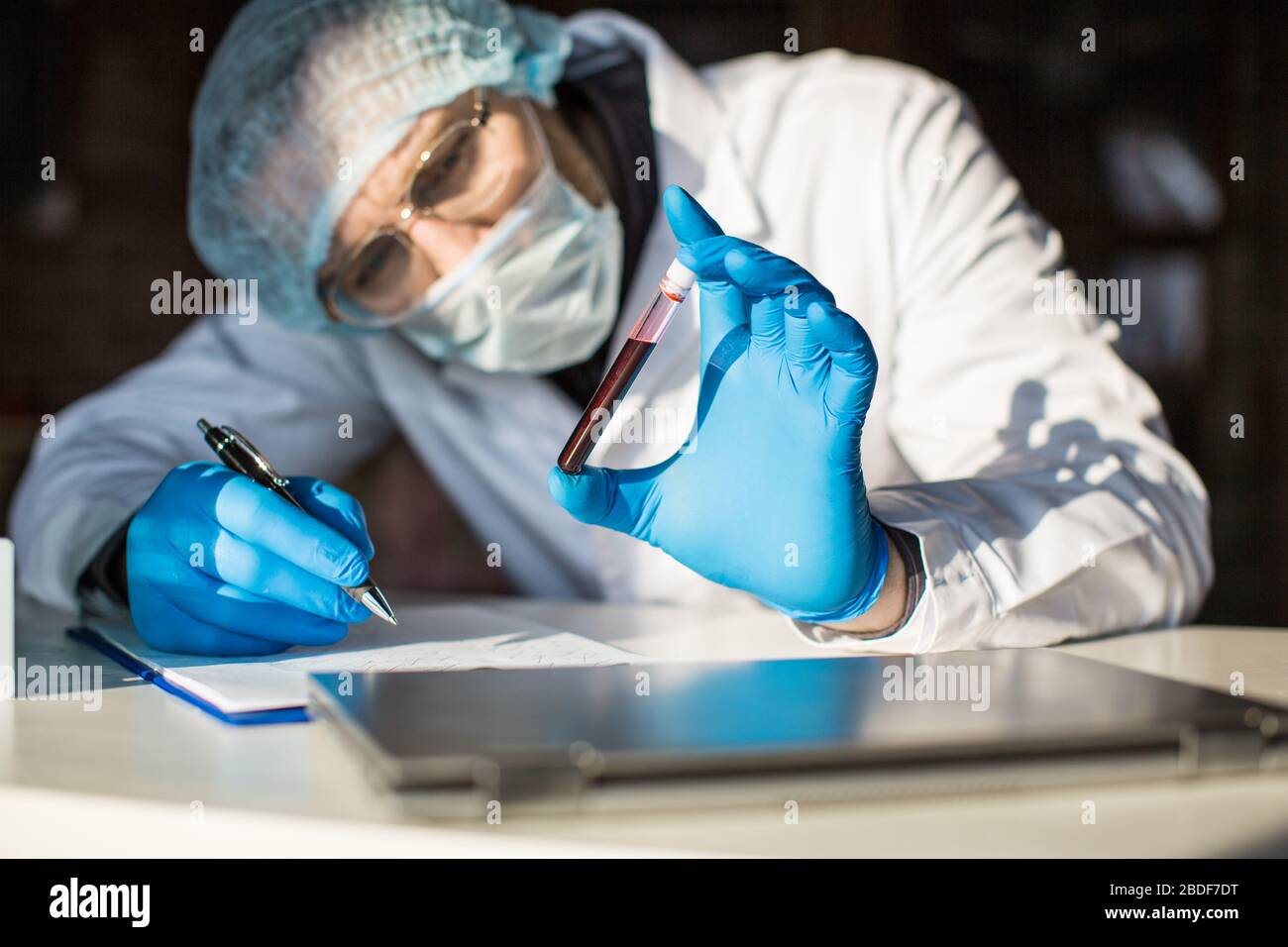 Close up view of blood sample in researcher's hands in test tube. Stock Photo