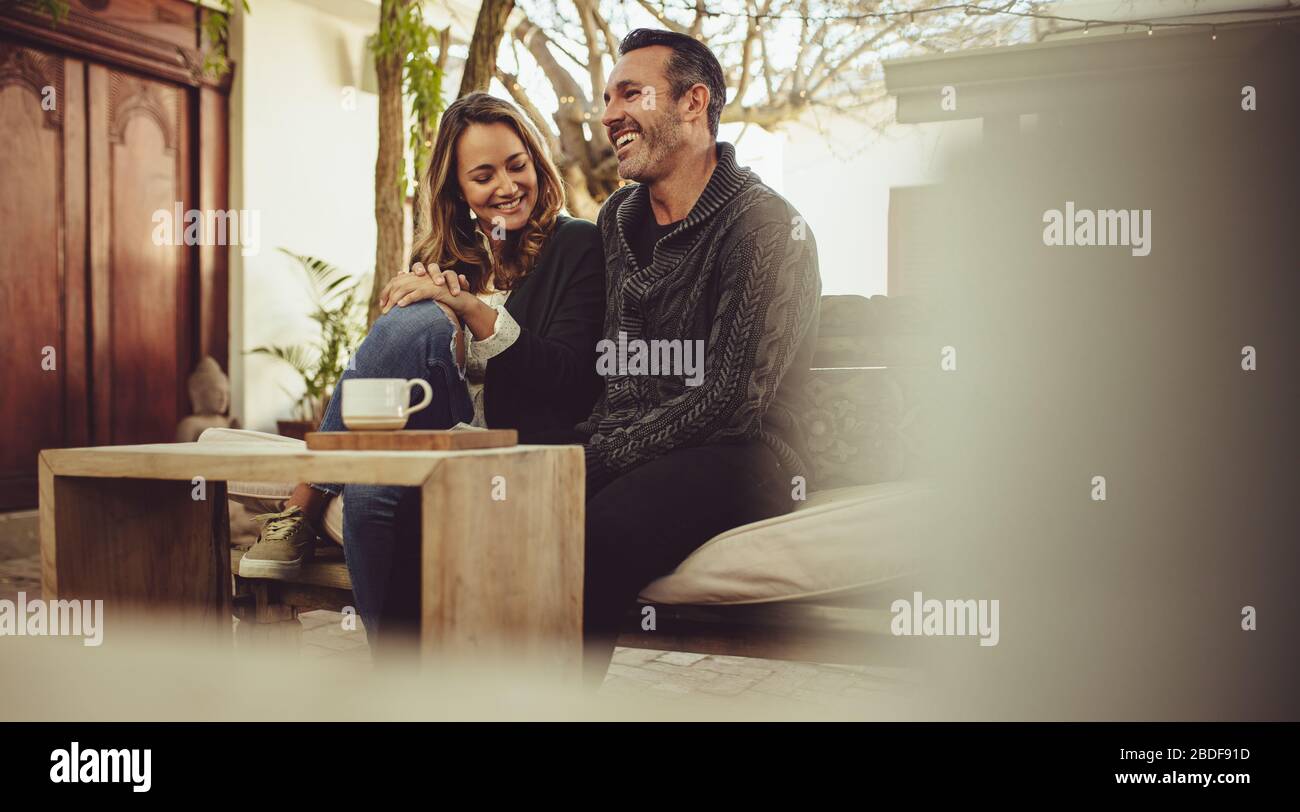Smiling man and woman sitting at coffee shop. Couple sitting at a cafe ...