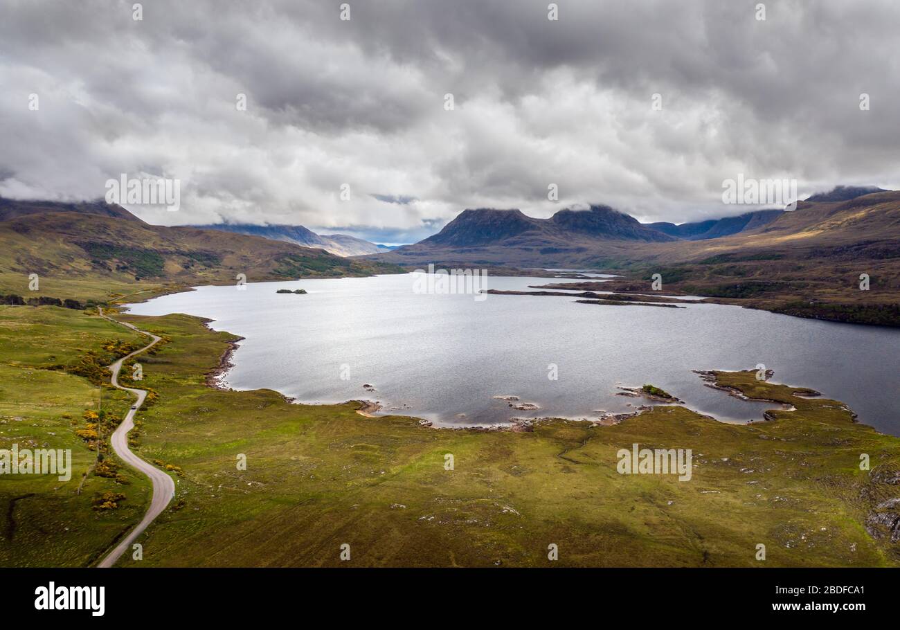 Aerial drone photo of 'Loch Bad a Ghaill', with with cloud capped mountains 'Stac Pollaidh' and 'Beinn an Eonin' behind. Assynt, NW Scotland, UK Stock Photo
