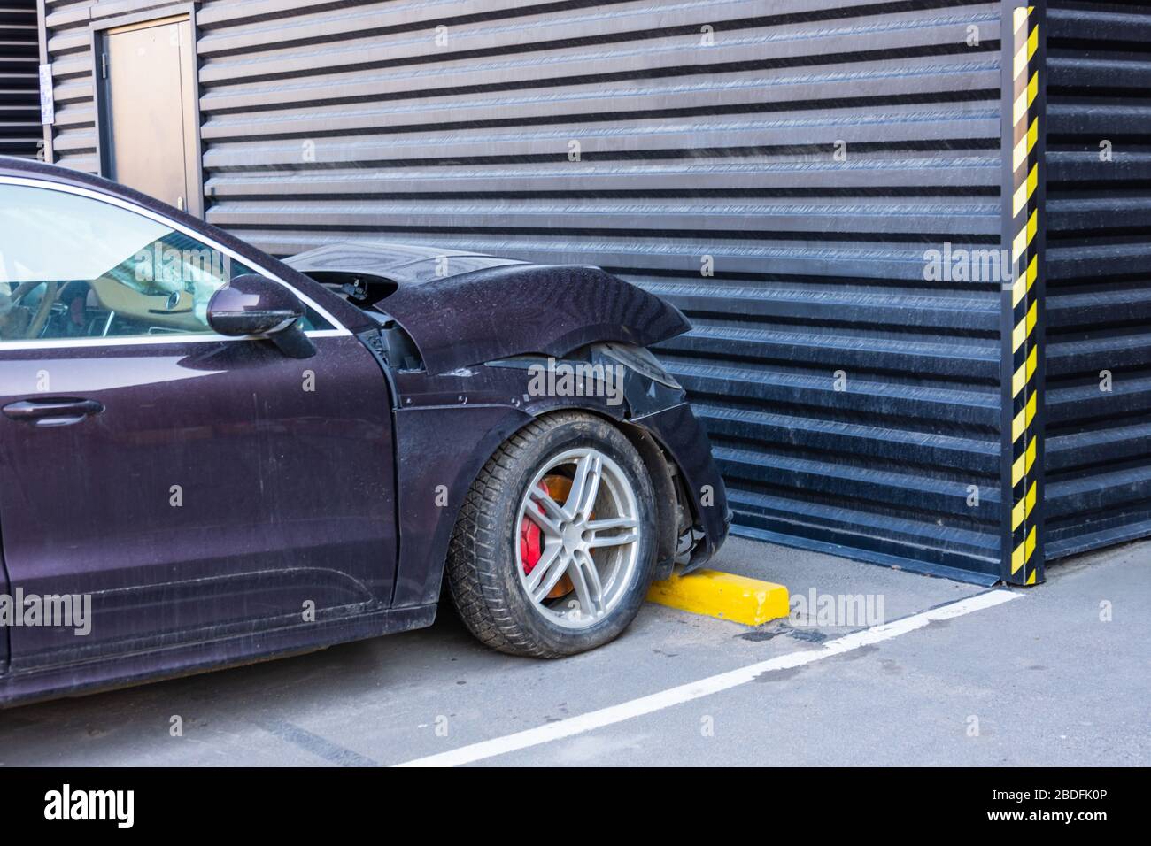 Broken hood and front bumper of a passenger car in a parking lot Stock