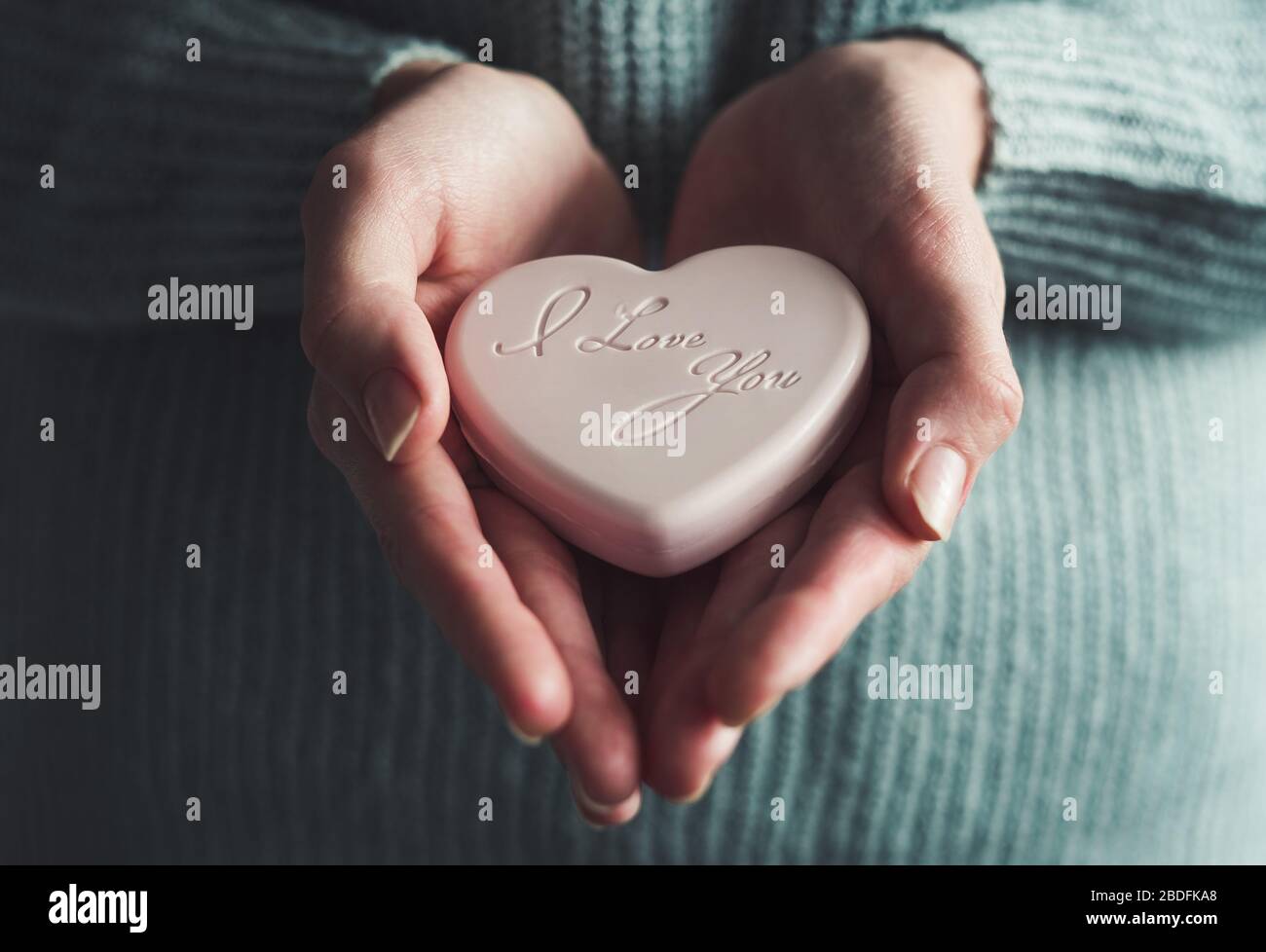 Soap in the shape of a heart in a girl's hand. Stock Photo