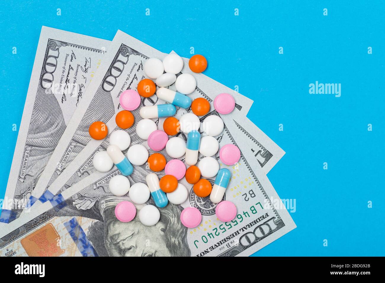 Medicine pills, tablets and capsules on US dollars background. Free space. Healthcare concept Stock Photo