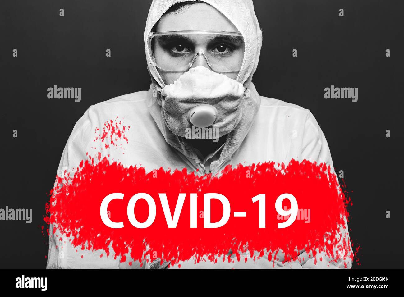 Text covid-19 on red warning sign on portret of man in biohazard chemical protective suit and face mask. Coronavirus pandemic quarantine zone. Concept Stock Photo