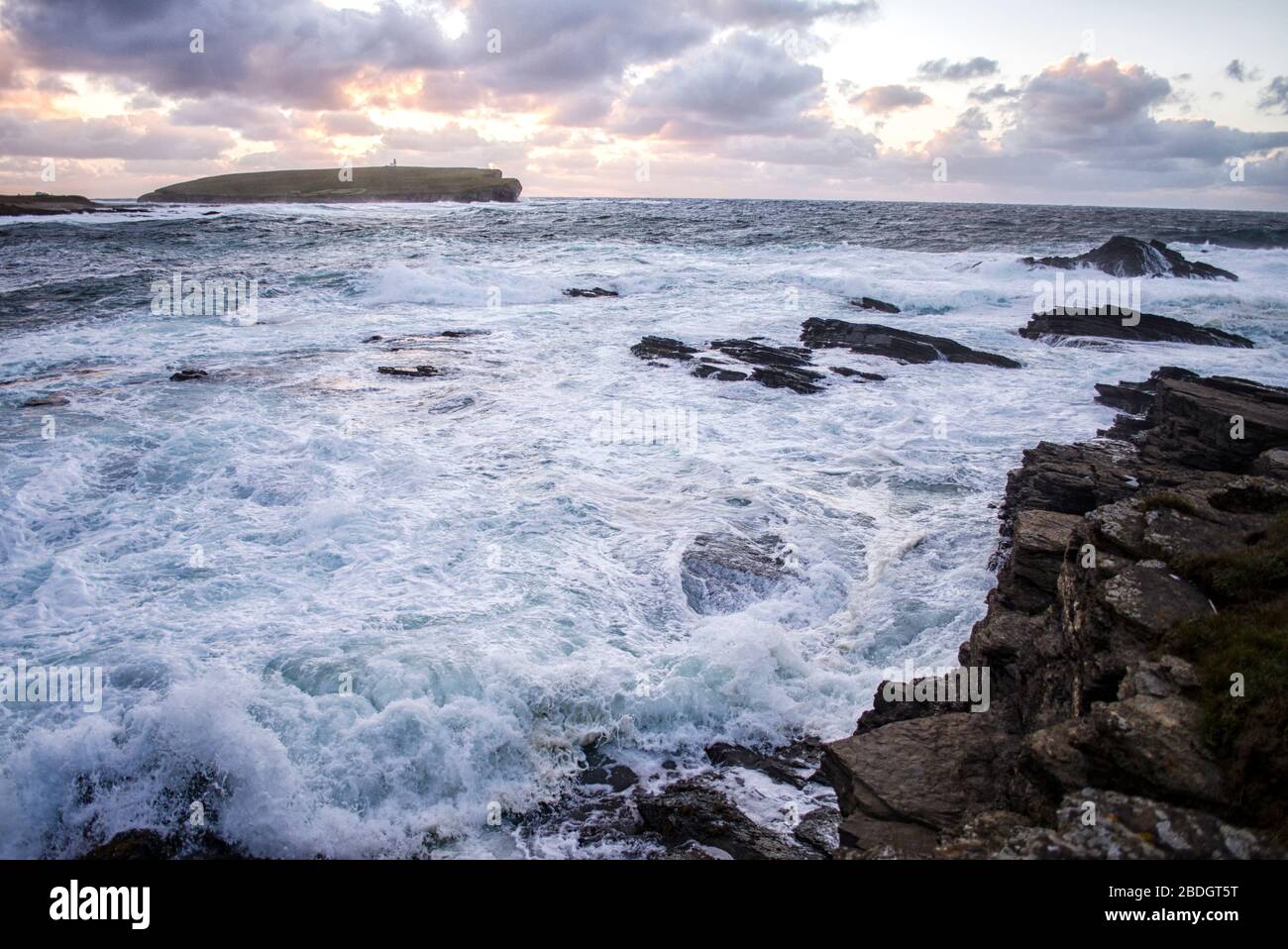 Sunset Over Coastal Landscape with Rough Waters Stock Photo
