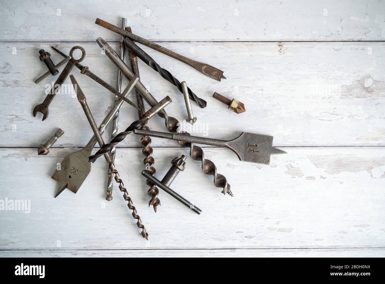 Vintage tools. Vintage drill bits against a white wooden background Stock Photo