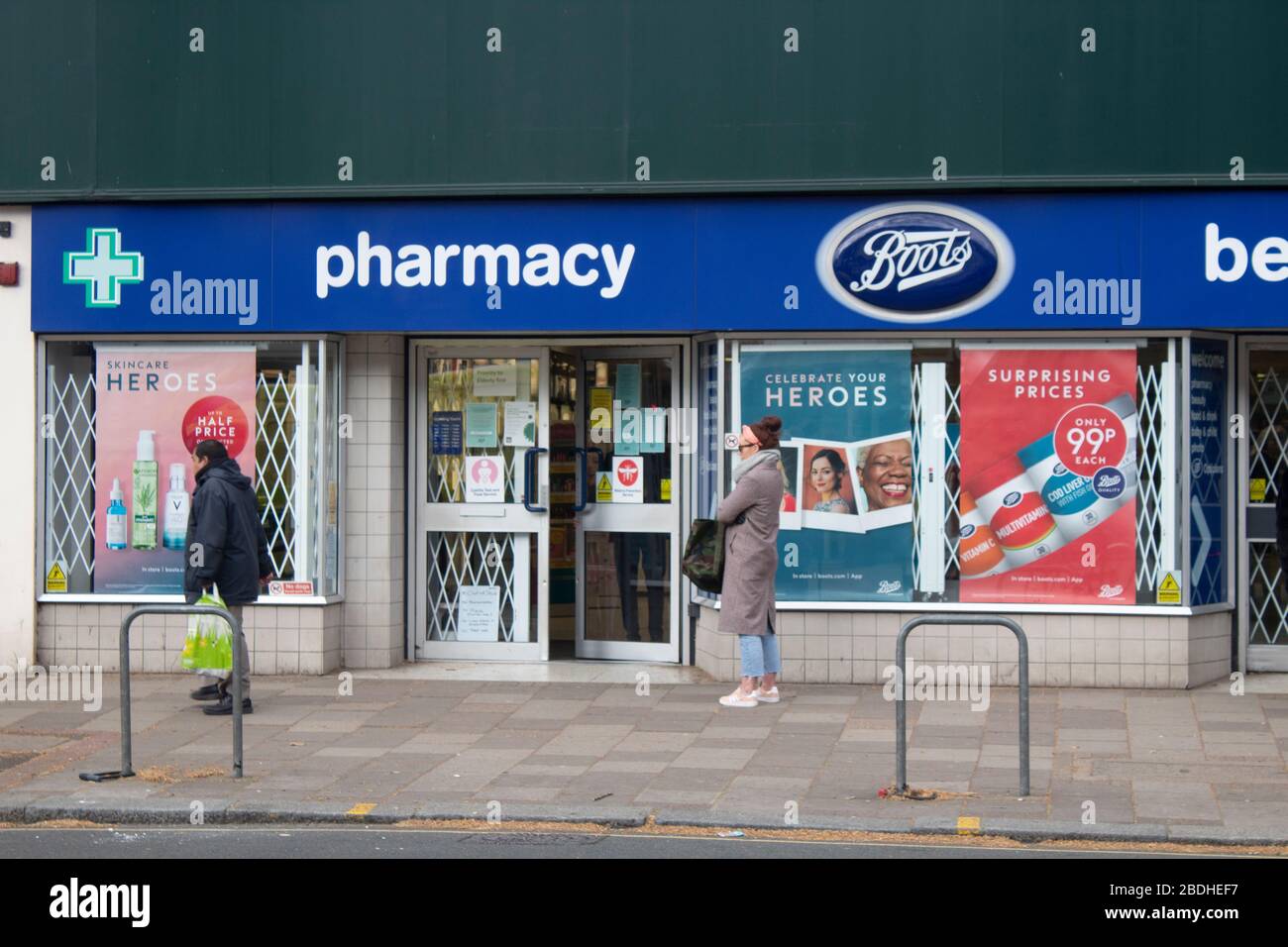 Shoppers waiting two meters apart to get into a Boots the Chemist during the Covid-19 pandemic, Chiswick, London UK Stock Photo