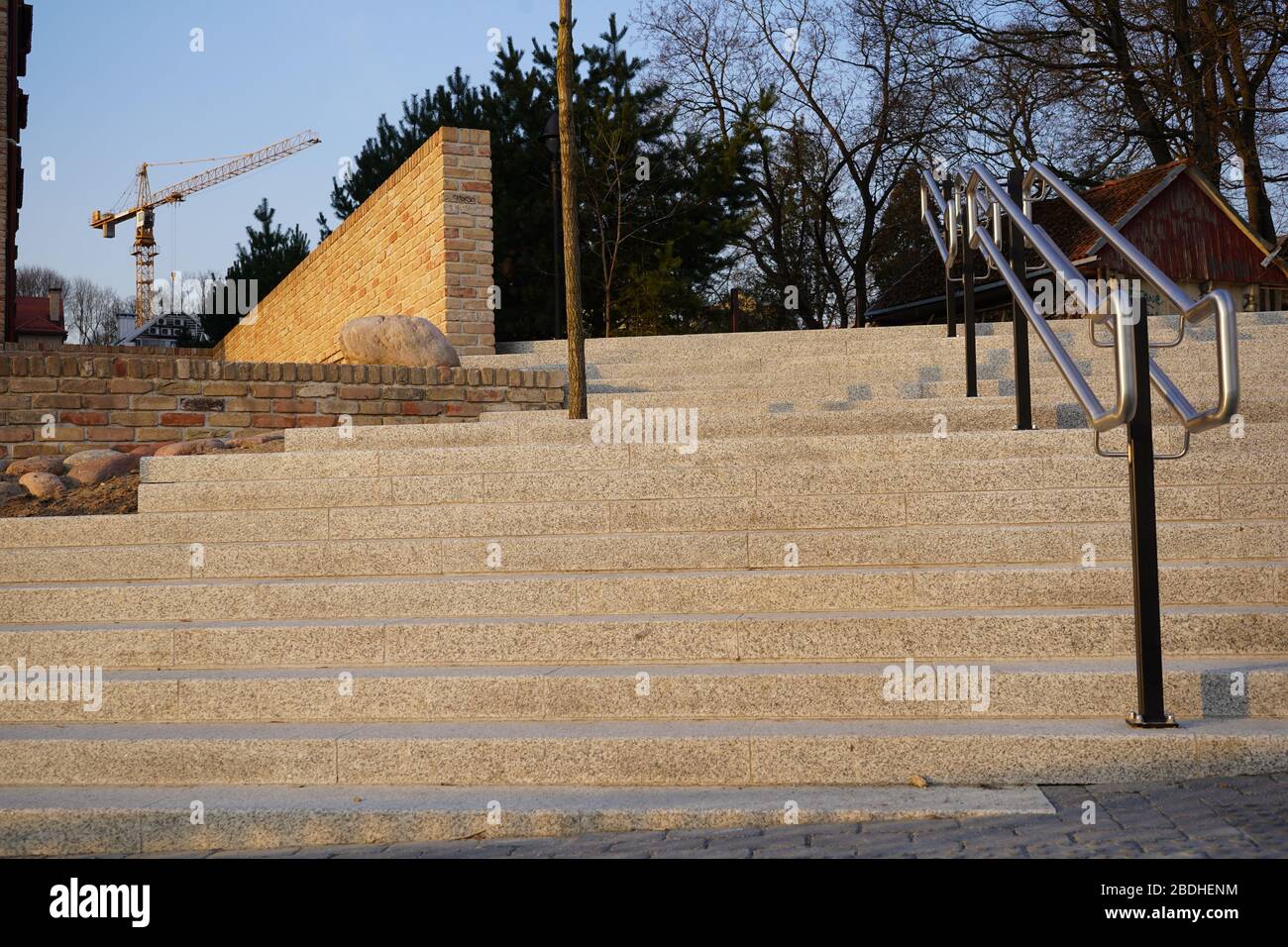 New stairs and fence from old bricks int he background. Huge crane in the background. Stock Photo