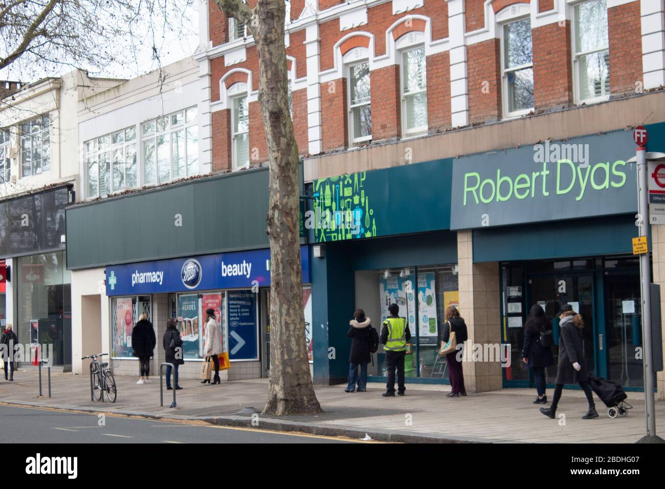 Shoppers waiting two meters apart to get into a Boots the Chemist during the Covid-19 pandemic, Chiswick, London UK Stock Photo