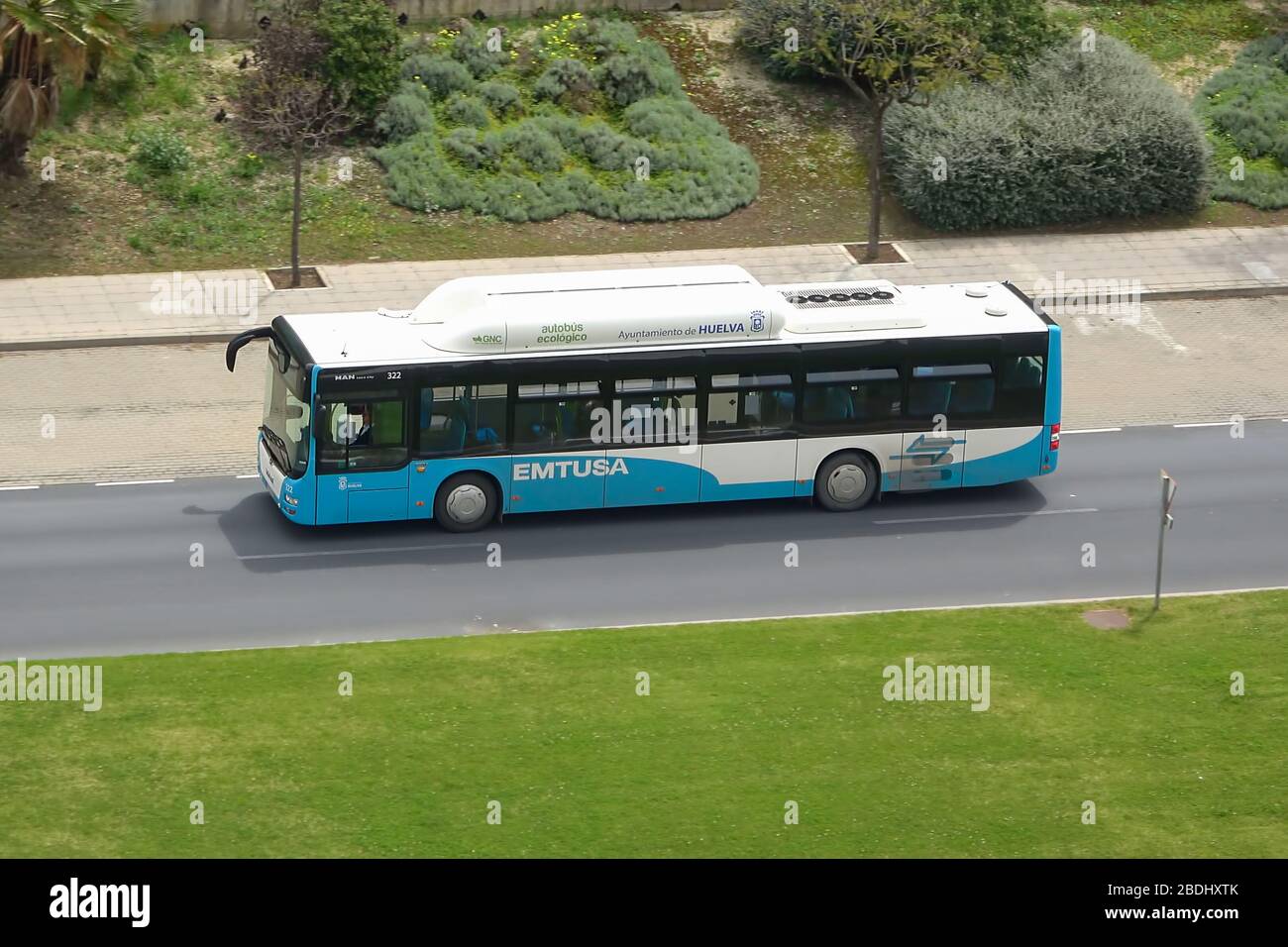 Huelva, Spain - April 6, 2020: Bus from public company EMTUSA moving on the road and going to HOLEA Mall during Spanish lockdown due to Covid-19 Coron Stock Photo