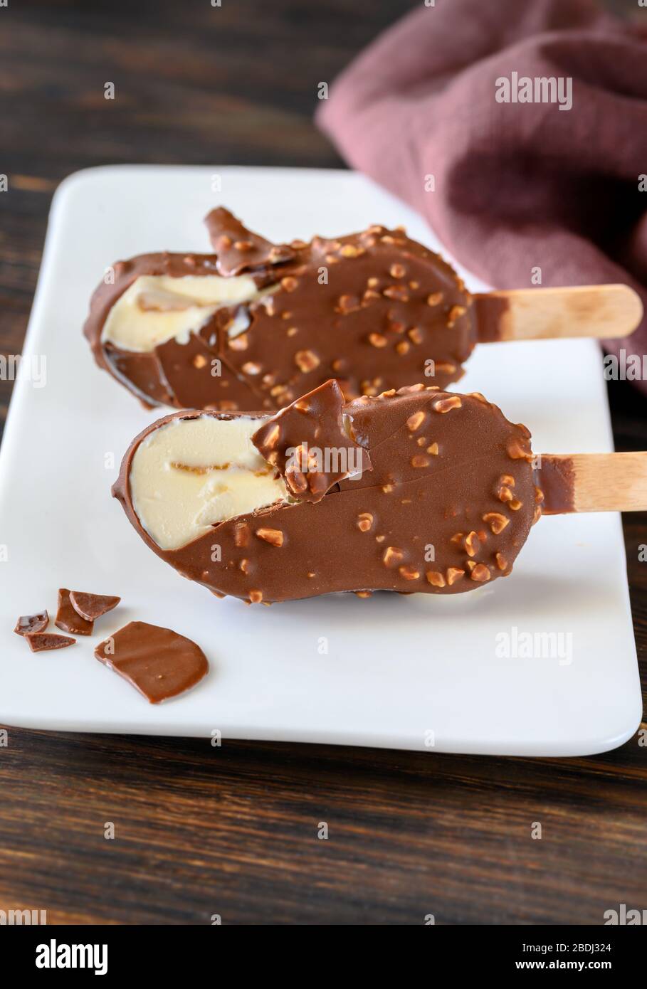 Chocolatecovered vanilla ice cream bar on the white plate Stock Photo