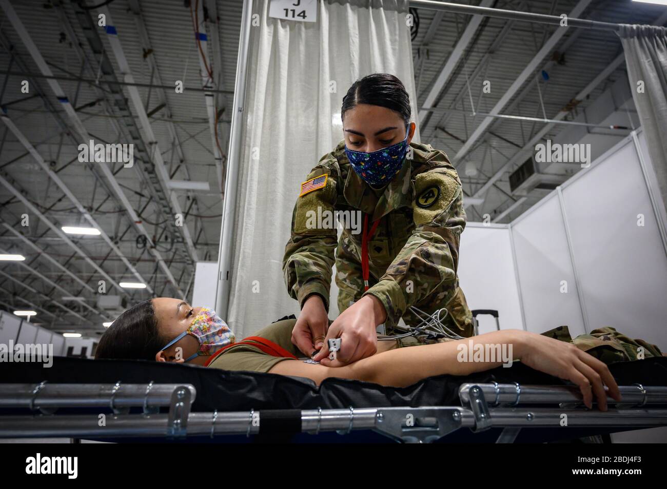New Jersey National Guard combat medic Spc. Kayla Awad tests an electrocardiogram machine in preparation for patients at a Federal Medical Station COVID-19, coronavirus pandemic relief facility set up at the Meadowlands Center April 6, 2020 in Secaucus, New Jersey. Stock Photo