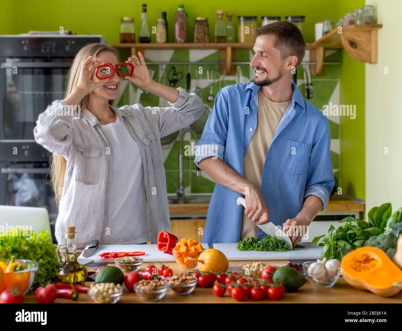 Funny young couple playing with vegetables together Stock Photo - Alamy