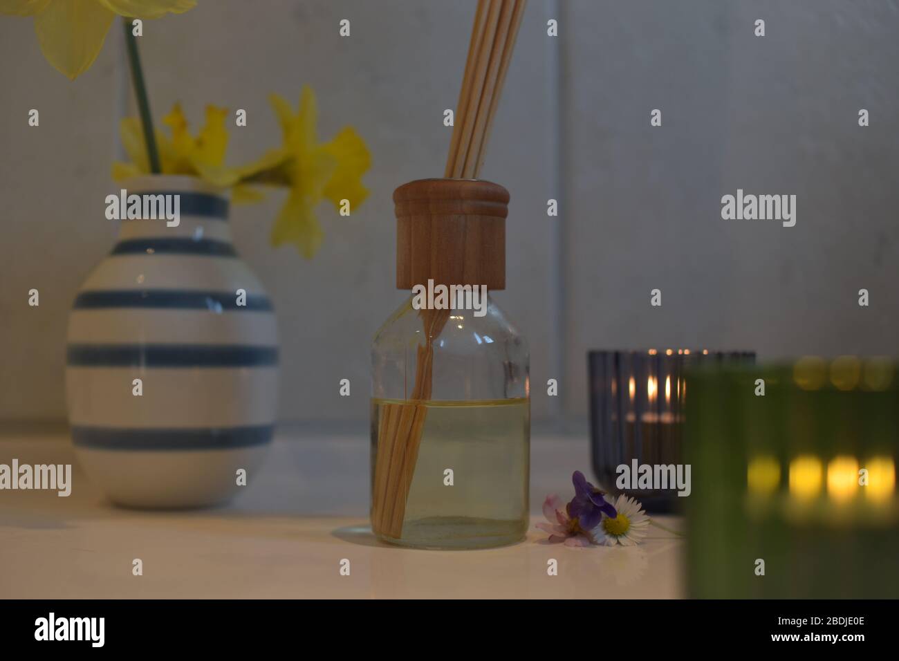 fragrance sticks in oil in bathroom with flowers and candles Stock