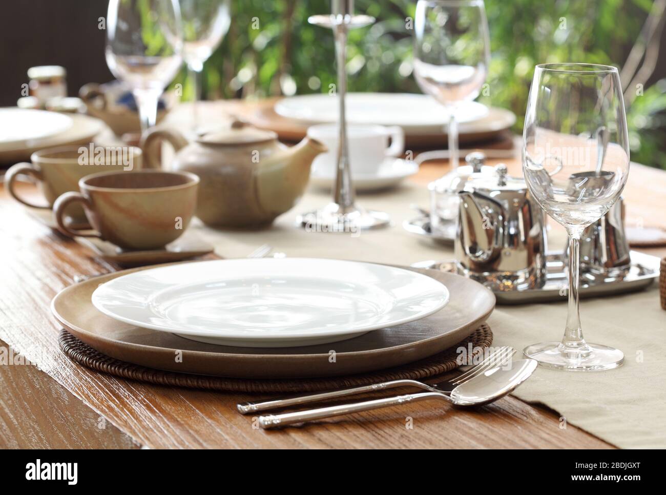 ethnic outdoor table setting on solid teak wood table Stock Photo