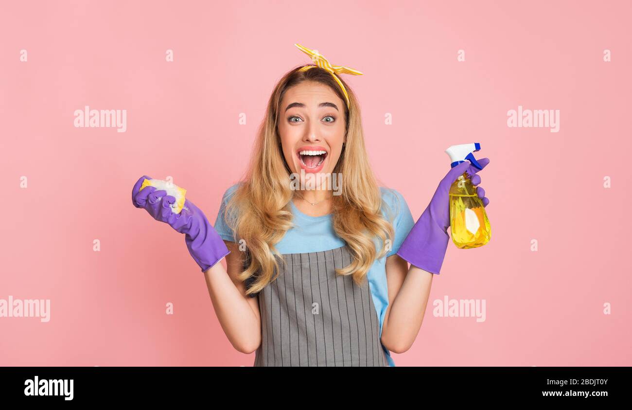 Housework with joy. Housewife in apron with rubber gloves Stock Photo