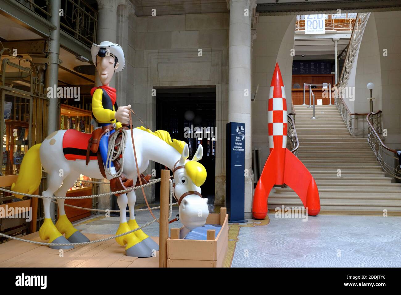 The statue of Lucky Luke and his horse Jolly Jumper and Tintin rocket display in the entrance hall of Belgian Comic Strip Center.Brussels.Belgium Stock Photo
