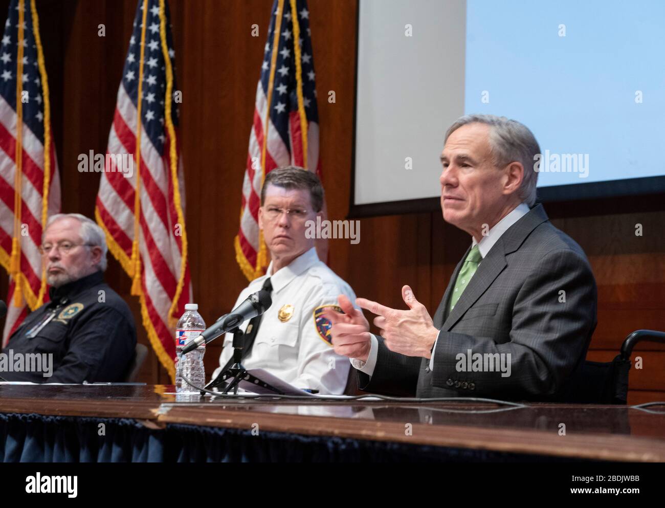 Texas Governor Greg Abbott, right, briefs the Capitol press corps on Texas companies ramping up voluntary production of face masks and face shields to meet soaring demand in combating the coronavirus epidemic. State Director of Emergency Management Nim Kidd, center, listens. Stock Photo