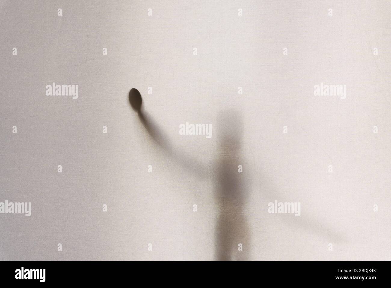 An artist wooden model standing up waving it's hand.  Shot through a semi transparent material. Creating a textured, blurred beautiful still life. Stock Photo