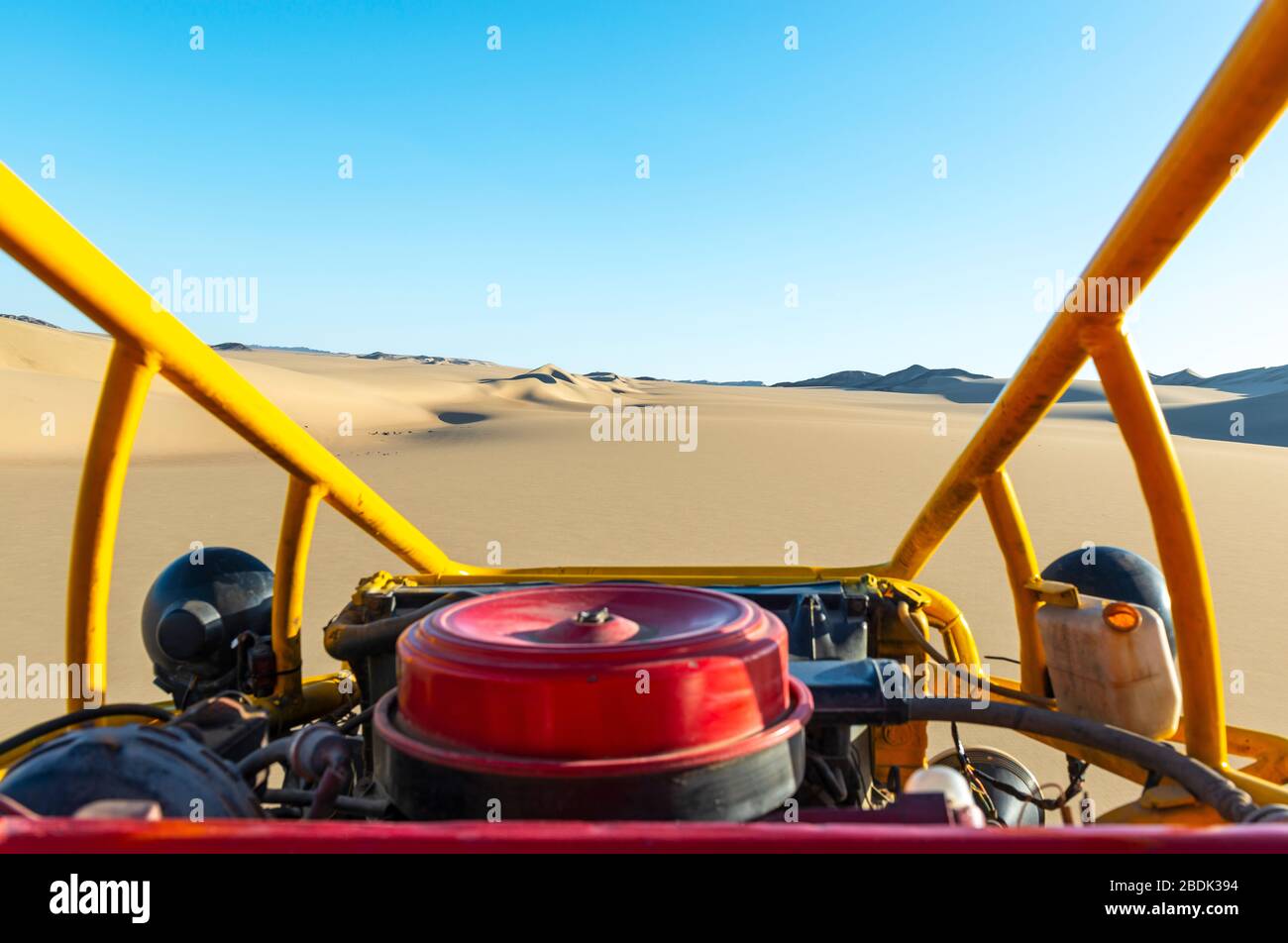 Engine of a desert buggy in the coastal desert of Peru between Ica and Huacachina. Sharp desert, unsharp engine. Stock Photo