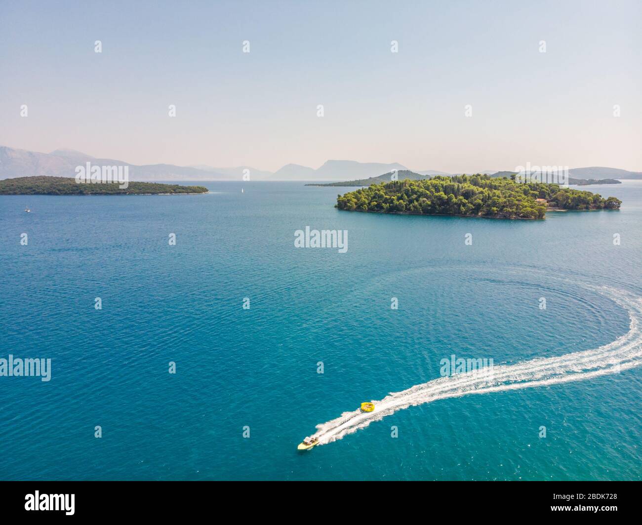 Tracking aerial shot of moving motor boat in  Lefkada, NIdri, Greece. Stock Photo