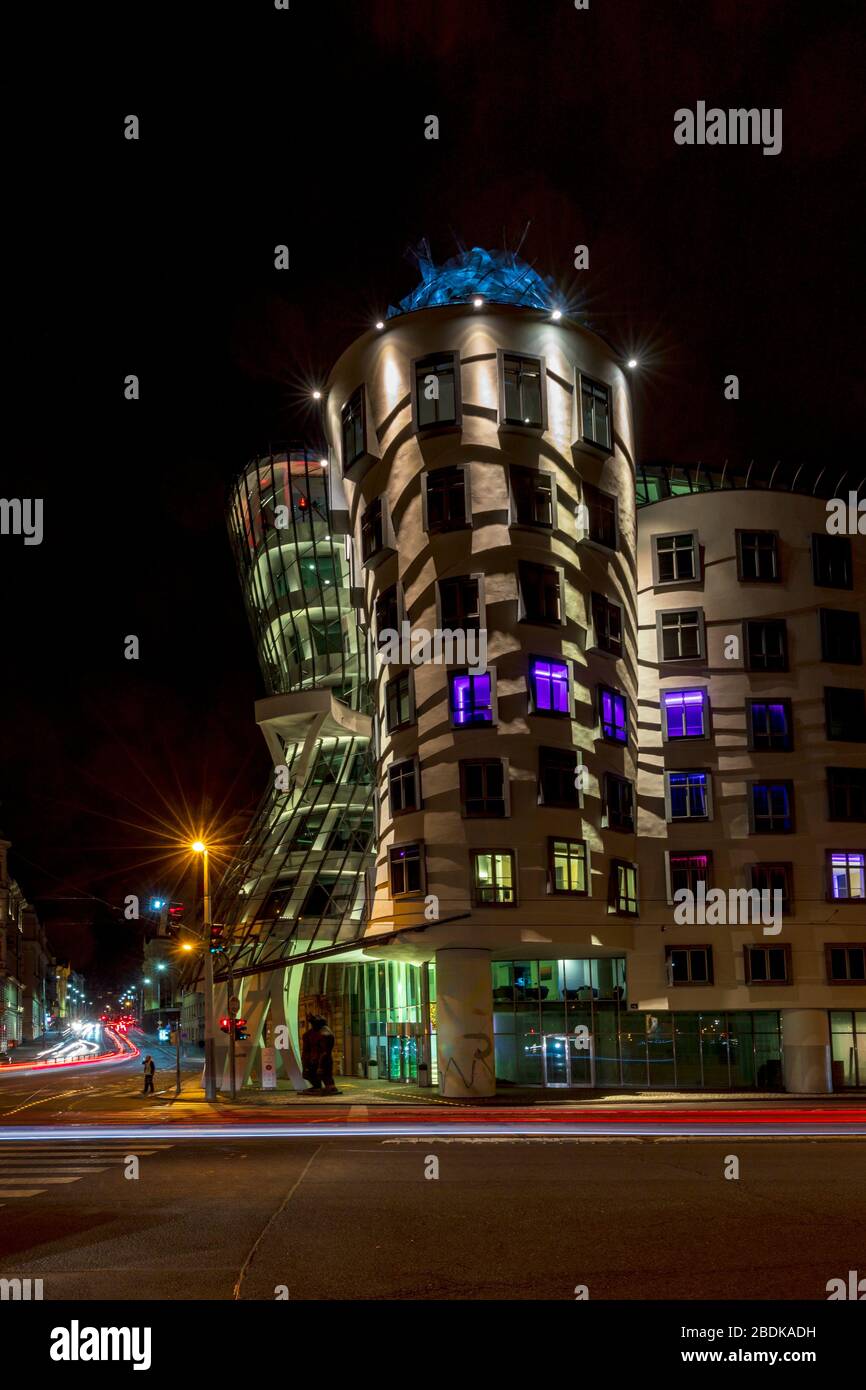 Light trails in front of the lit Dancing House building in Prague at night. The building was designed by the Croatian-Czech architect Vlado Milunic. Stock Photo