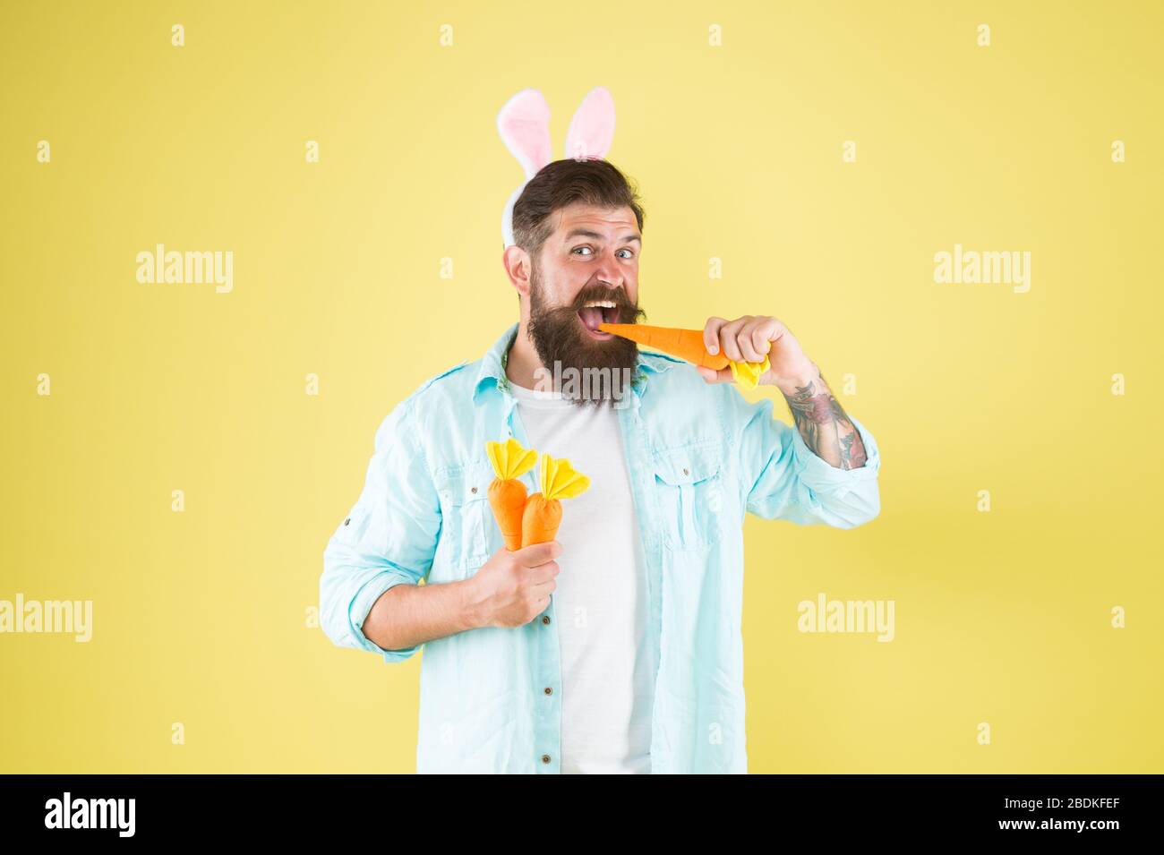 Carrot consists vitamins. Happy and healthy. Easter bunny hold carrots