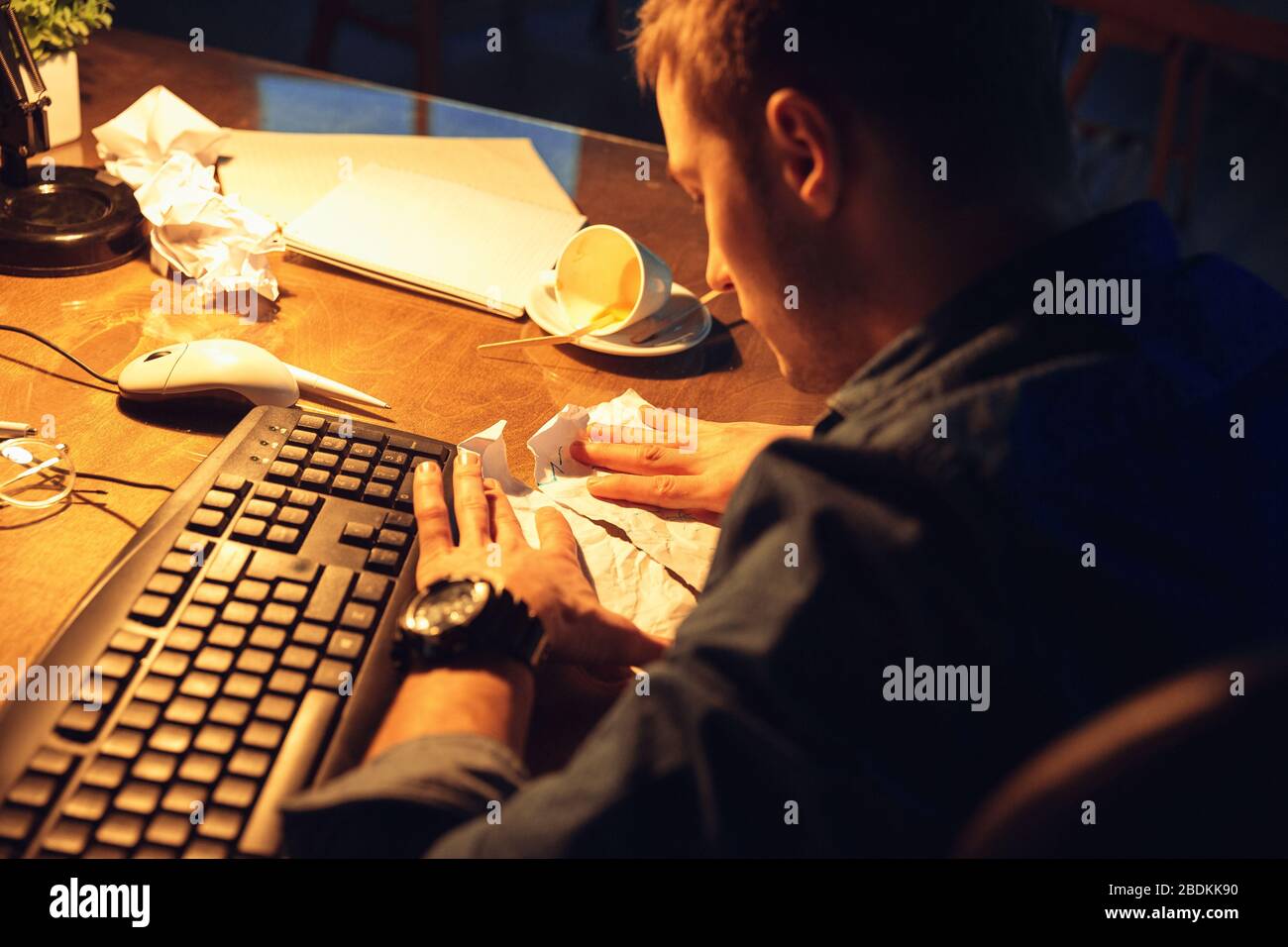 Going crazy. Man working in office alone during coronavirus or COVID-19  quarantine, staying to late night. Young businessman, manager doing tasks  with smartphone, laptop, tablet in empty workspace Stock Photo - Alamy