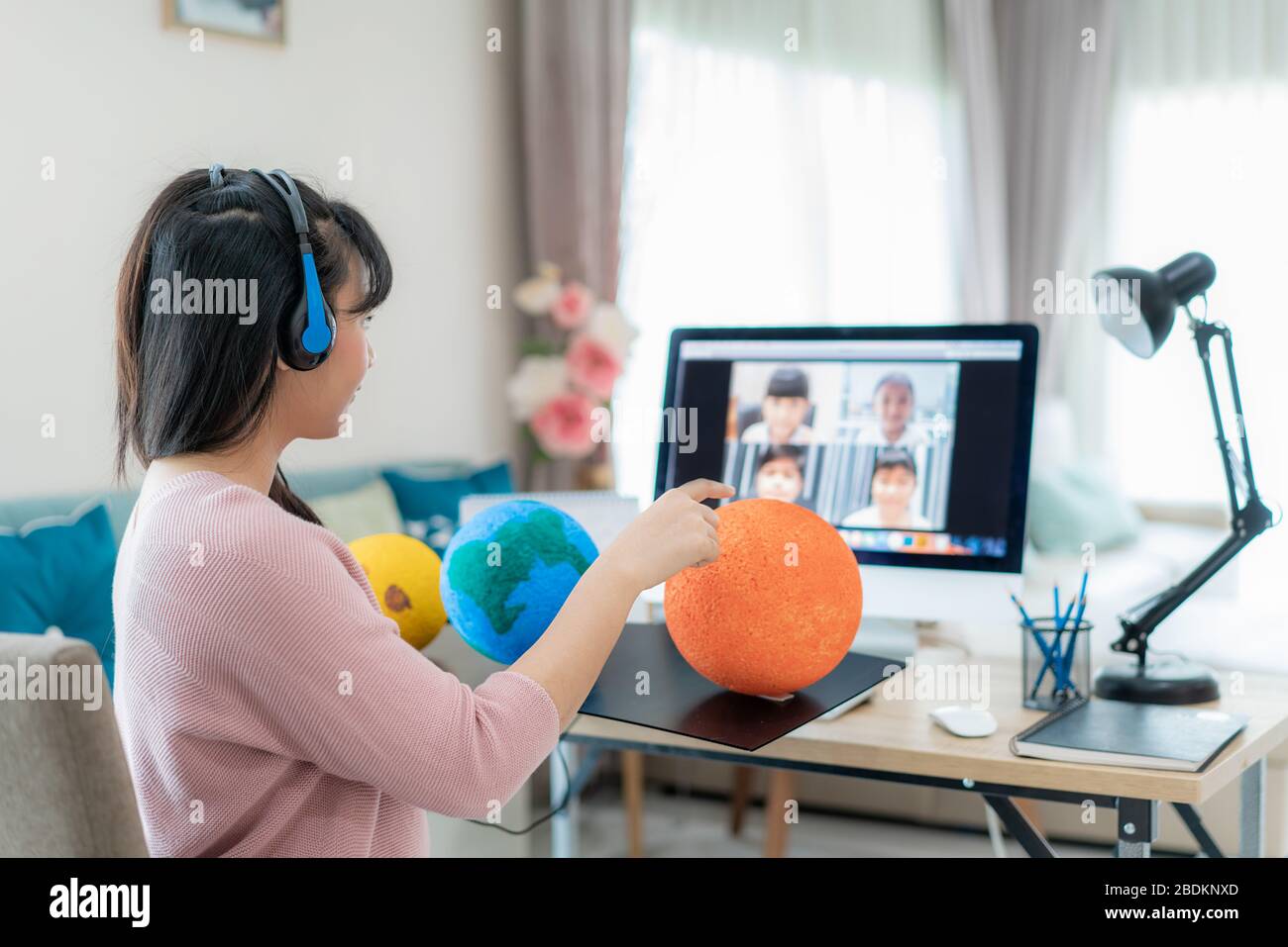 Asian woman teacher teaching solar system via video conference e-learning and cheerful elementary school student looking at globe, Homeschooling and d Stock Photo