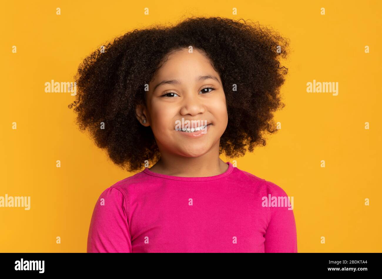 Portrait of pretty little black girl smiling and looking at camera ...