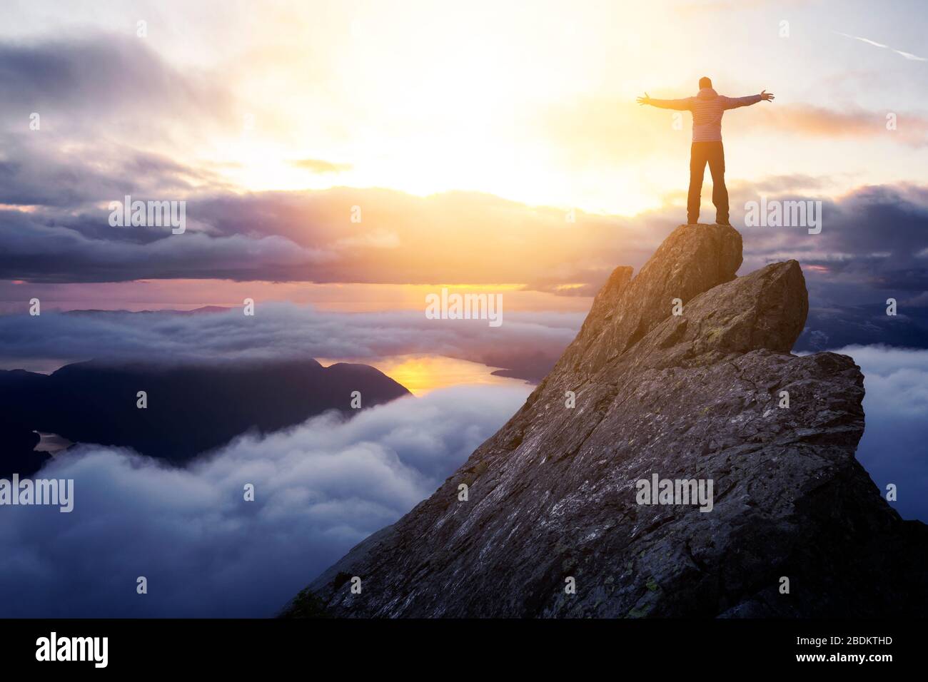 Adventurous Man Hiker With Hands Up on top of a Steep Rocky Cliff Stock  Photo - Alamy