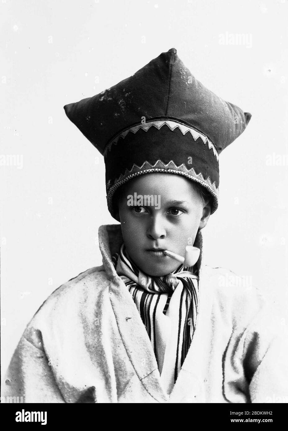 Gutt i samisk drakt, kofte og lue, med pipe i munnen Stock Photo